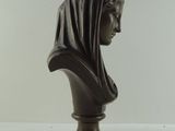 bronze bust of a woman wearing a headscarf on a pedestal
