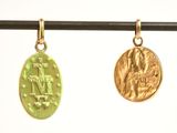 two gold coins hanging from a wire on a white background
