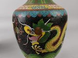 a vase with a dragon painted on it sitting on a table