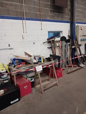 un homme debout dans un garage avec un skateboard