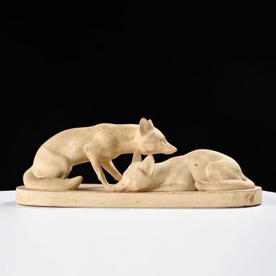 une photo représentant une sculpture d'un chien et d'un chat posée sur une table