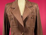 brown jacket on a mannequin stand against a red background