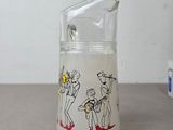 a glass pitcher with a picture of a band playing on it