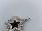 a close up of a star pendant on a white surface