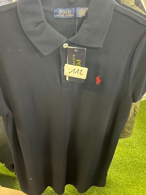 black polo shirt on display in a store with a price tag