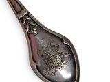 a silver spoon with a design on it on a white surface