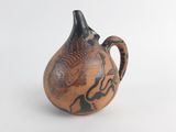 un vase marron orné de motifs noirs sur un fond blanc