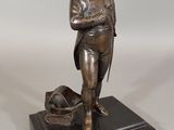 bronze statue of a man with a hat on a black base