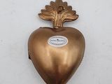 brass heart with leaf decoration on a white background