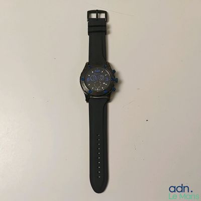 une montre posée sur une surface blanche