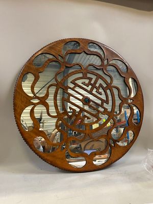 a mirror that is sitting on a shelf next to a vase