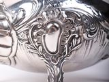 a silver vase that is sitting on a table