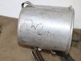 a silver cup with writing on it sitting next to a pair of scissors