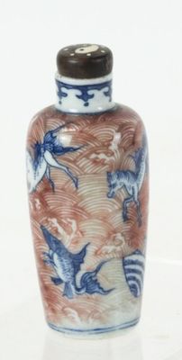 a small blue and white vase with birds on it