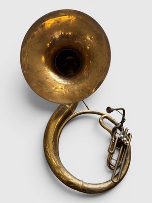 un vieil instrument de musique en laiton muni d'un pavillon, sur fond blanc
