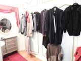 a lot of clothes hanging on a rack in a room