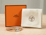 an orange box with a white cloth and a silver bracelet