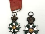 deux médailles et un ruban rouge sur un fond blanc