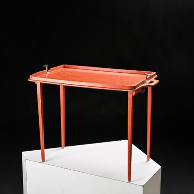 un plateau orange posé sur un support blanc, sur fond noir