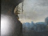 une peinture accrochée au mur d'un immeuble, représentant une vue de la ville