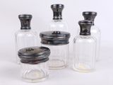 trois bocaux en verre transparent avec des couvercles noirs et un bouchon en bois