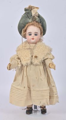 an old fashioned doll with a hat and coat on a white background