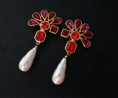pair of red and white earrings with pearls on a black background