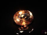 a close up of an orange diamond on a black surface