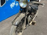 une vieille moto garée devant un immeuble