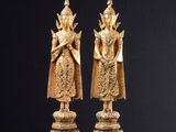 deux statues en or représentant une femme et un homme, posées sur un socle