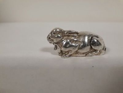 une figurine en argent représentant un chien assis sur une table
