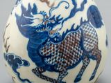 a blue and white vase with a picture of a dragon on it