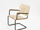 the chair is made of wood and metal with a leather seat