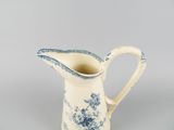 an image of a blue and white pitcher on a gray background