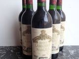 six bottles of red wine are lined up on a table
