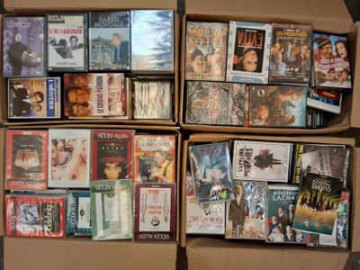 un grand nombre de DVD dans une boîte en carton posée sur le sol