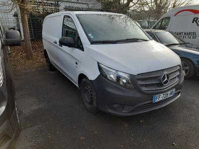 une camionnette blanche garée dans un parking à côté d'autres voitures