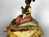 a figurine of a man riding a horse on top of a pile of pillows