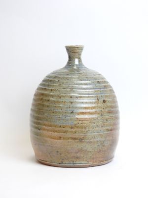 a small vase that is sitting on a white surface