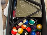 a box full of pool balls and other items on the floor