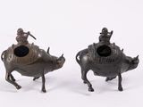 pair of bronze figurines of a man riding a bull and a woman riding a cow