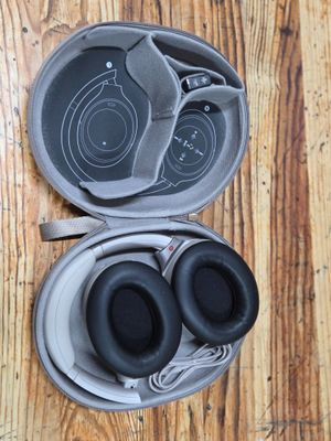 a pair of headphones in a case on a wooden floor