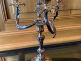 un chandelier en argent posé sur une table en verre dans une pièce