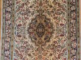 un tapis persan antique sur un plancher en bois