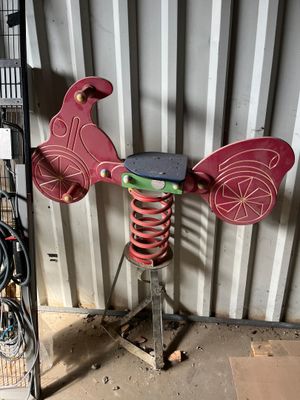 un moulin à vent rouge et vert posé sur un support métallique
