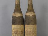 two bottles of wine sitting on top of a table next to each other