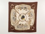 un foulard carré marron et blanc accroché à un mur