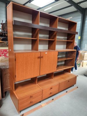 une photo d'une grande bibliothèque en bois avec des tiroirs et des étagères
