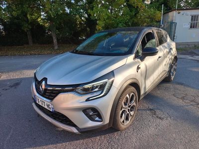 une voiture argentée garée sur le bord de la route, devant une maison