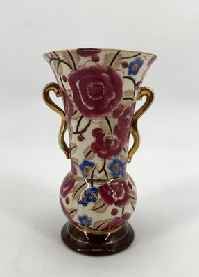 a vase with a floral design on it sitting on a table